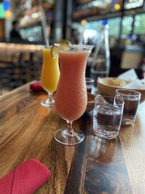 Mango  and guayaba margaritas and glasses of water and their chip and salsa.