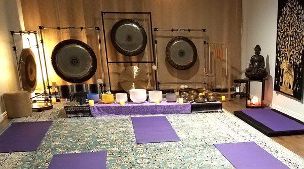 Set up for a group sound bath with gongs, crystal bowls, Tibetan bowls, and other instruments. Space can accommodate 15 people.