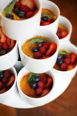 Tasty tower of creme brulee topped with fresh berries and mint.