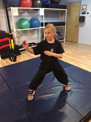 Youth Kung fu student Kylee Cook standing in right bijong with open guard.