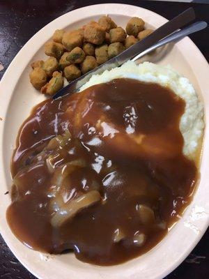 Hamburger steak with mashed potatoes and fried okra.