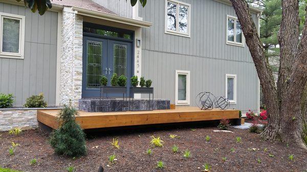 This home was dramatically improved thanks to the stone work design entrance, matching plantings area, and open deck entrance.