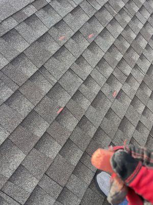 Adjuster marking storm damage on the roof from a recent storm