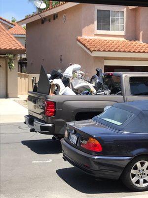 a lot of precious belongings piled onto someone's pickup truck since the inefficiency of the packers left not enough room for all our stuff