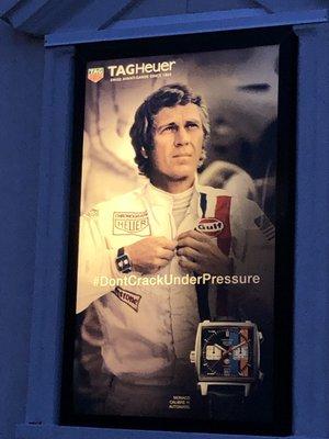 6/11/19. Tuesday night. Steve McQueen aglow on the building side in the darkness. A TAG Heuer watch advertisement.