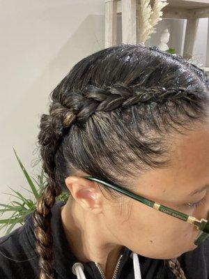 Messy braids , hair already coming out , and blobs of gel thrown on.