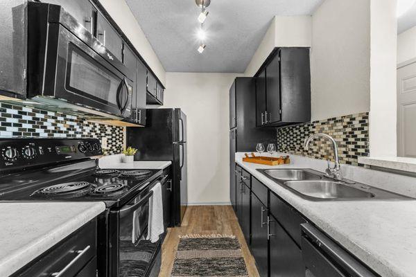 a kitchen with black cabinets and white countertops