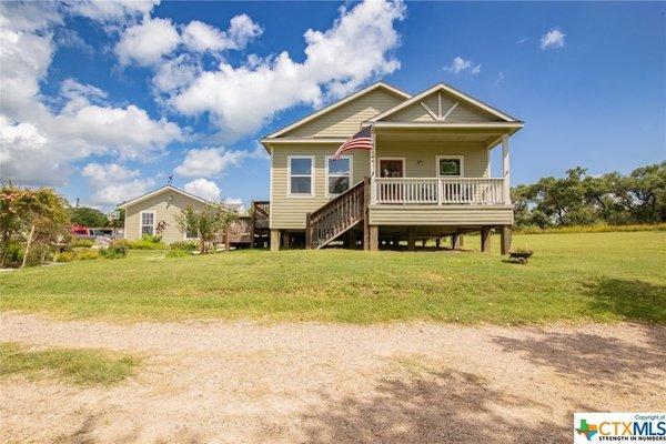 beachfront home and property with a large yard