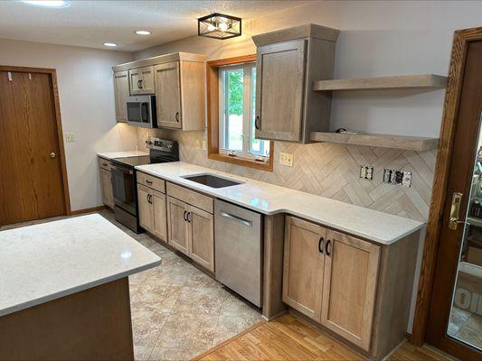 Refacing project with new maple doors, quartz countertops, and tile backsplash.