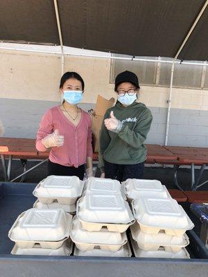 Two other volunteers passing out boxes.