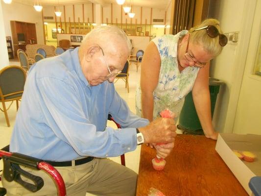 Baker of 35 years teaches staff and residents how to decorate cupcakes.