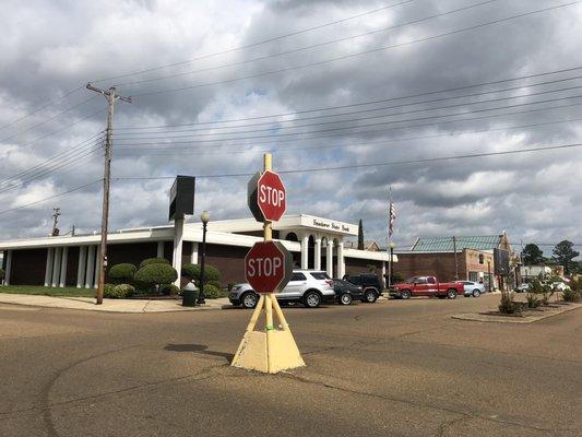 One of two stop signs that stands in the middle of an intersection, too