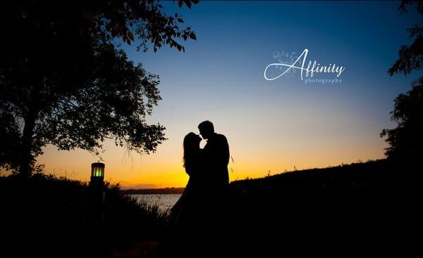 Bride and groom share a kiss as the sun sets over Seattle.