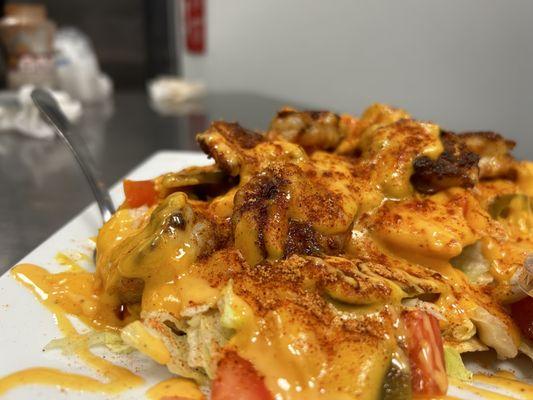 Grilled Shrimp Nachos with lettuce tomatoes drizzled with Nacho Cheese