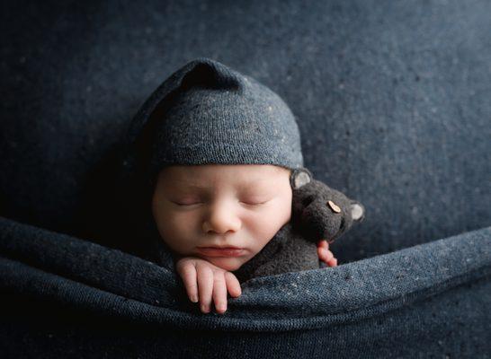 A tiny stuffed mouse and an adorable baby boy.