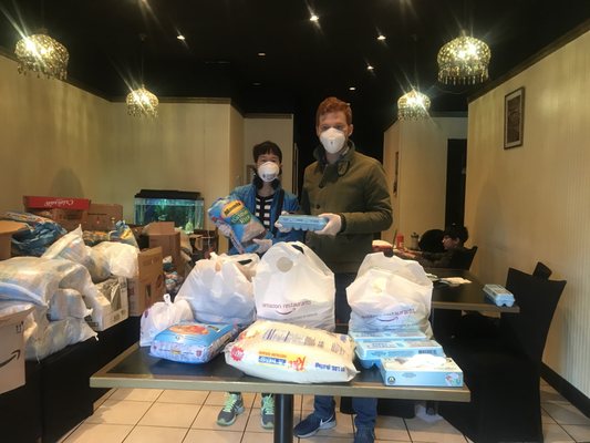 Volunteers Angie & Ryan packing up to deliver groceries from the Jalsa Grill & Gravy dining room which has been converted to a sorting area!