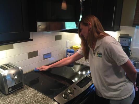 Christy Wheeler, from St. Pete Cleaning Service, is cleaning the ceramic smoothtop of a stainless steel slide-in Kenmore range.