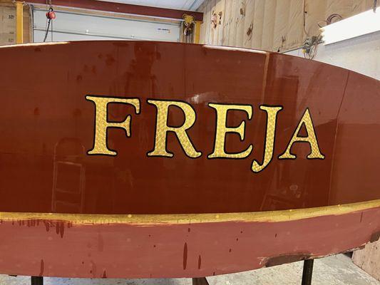 Hand painted, hand engine turned gold leaf transom on antique, classic mahogany boat transom.