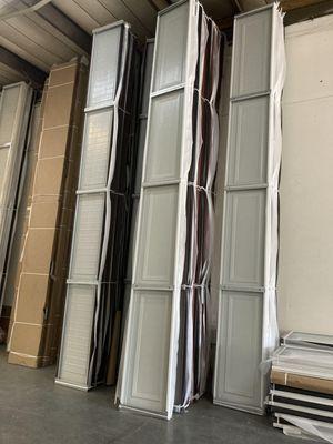 A picture of long garage door panels stacked up vertically against a wall