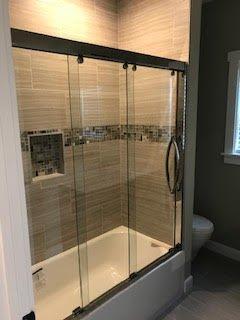 Standard Glass enclosed shower - staccato brown accent on birch tone tile