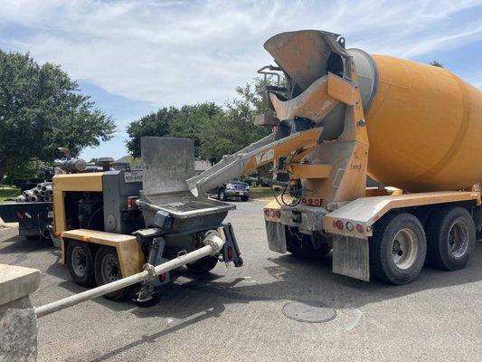 Concrete truck loading grout into a pump truck. Existing voids after foundation leveling were filled