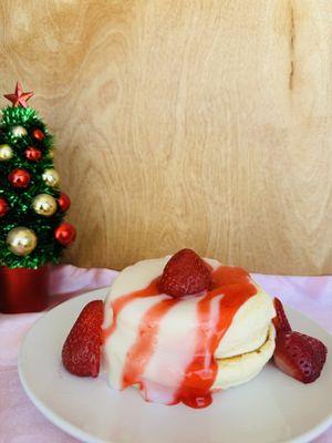 Strawberry Delight: Soufflé Pancakes with milk sauce, fresh strawberries, and strawberry sauce.