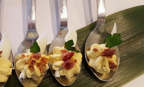 Deviled egg bites on a silver spoon