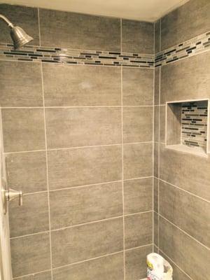 The $1 grey porcelain tile, and $9 backsplash tile installed (by our contractor) in our shower