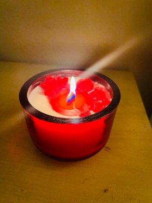 Rose scented candle with red rose accents in a red glass vessel and wood wick