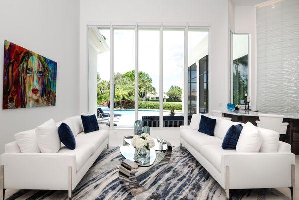 Modern Living Area with white sofas using performance fabrics and steel legs. An S-shaped tempered glass cocktail table completes the view.