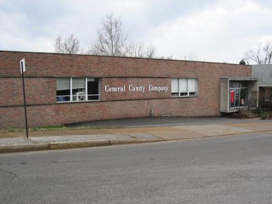 Driveway down the right side of the building with parking and entrance in the back