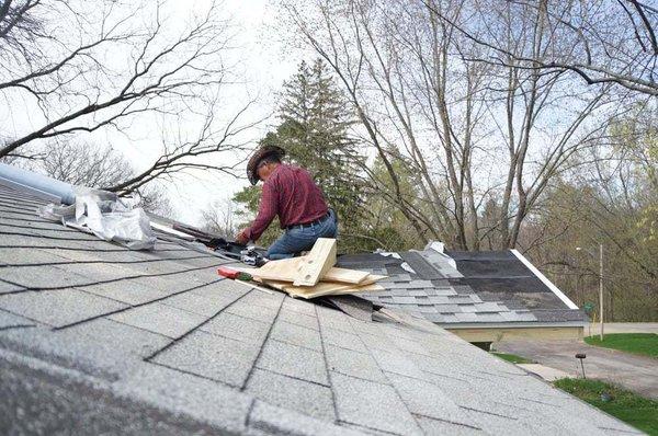 R S Toyama installing shingles in Madison, WI, wearing a hat borrowed from his daughter who thought it paired well with the f...