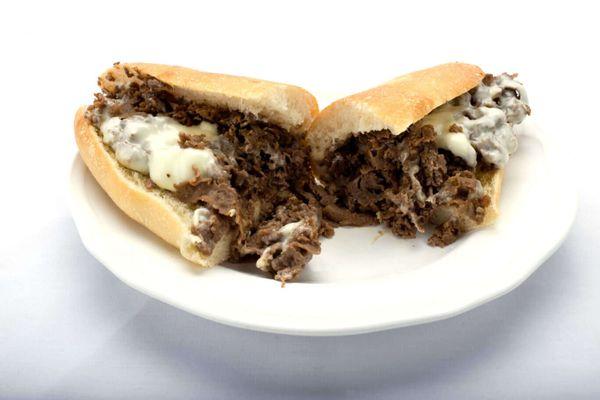 A plate featuring a delectable half of a cheesesteak sub from Genova's To Go. Pure sandwich perfection!