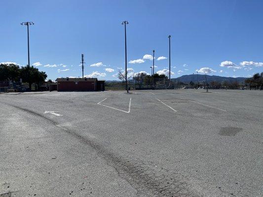 Parking lot with ball field with lights.