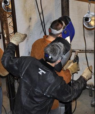 Instructor James Stanton coaching a new welder on SMAW welding techniques.