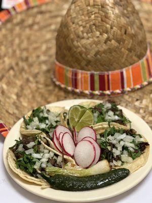 Street steak tacos, topped with onions and cilantro.