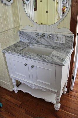 White custom vanity cabinet with marble top