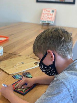 Coloring the puzzle he just created on the laser cutter at The STEMzone