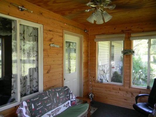 Enclosed front porch gives the feel of a fishing cabin.  Good fishing across the road in Lake Mohee.