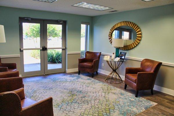 A bright, calm, friendly lobby in tranquil pale blues and greens. Comfortable homey brown leather chairs for clients and guests.