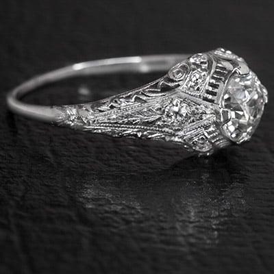 Platinum Art Deco Ring with filigree details and diamond accents.