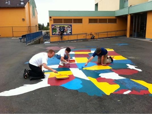 Volunteers painting a US map in Laurel elementary school