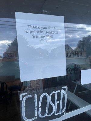 Sign on coffee shop door saying it's closed for the season.