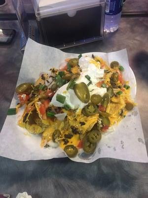 Arena supreme nachos served with cheese, onions, tomatoes, sour cream, and a choice of carne Asada or chicken.  delicious