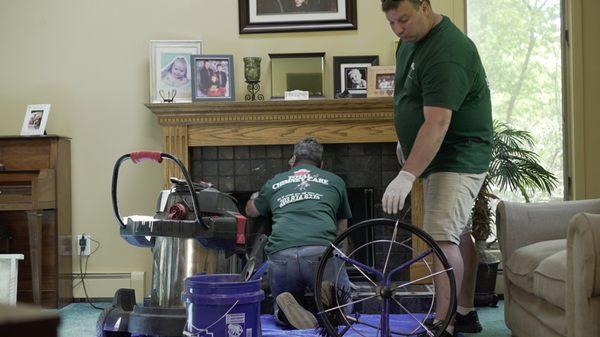 Chimney technicians sweeping a chimney