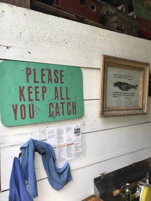 Signage in barn where they give you pole and bait and clean the fish.