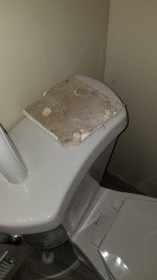 Sheetrock from the hole, left on back of toilet