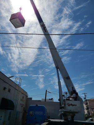 Putting a new AC on a commercial building. Cranes are a huge help with these installs.