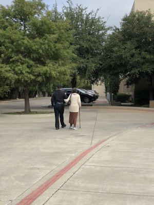 Officer escorting an elder lady to the Yom Kippur service.