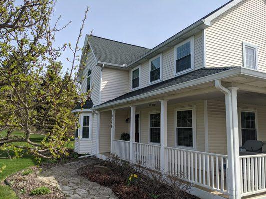 Before and After:  We sprayed this vinyl exterior white and we stained the deck and new posts by hand.